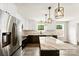Bright kitchen with stainless steel appliances, center island with marble countertop, and wood-look flooring at 1451 Cherryville Rd, Shelby, NC 28150