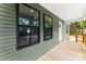 Cozy covered porch with wood decking, green siding, and windows that let in natural light at 1451 Cherryville Rd, Shelby, NC 28150