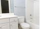 Cozy bathroom with tub, toilet, and vanity with drawers and cabinet, featuring patterned wallpaper and blue knobs at 19113 Southport Dr, Cornelius, NC 28031