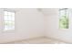 Bright bedroom features neutral carpet and white walls, with two large windows offering natural light at 19113 Southport Dr, Cornelius, NC 28031