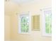 Sunlit bedroom with yellow walls, white trim, and two windows offering natural light and charming architectural details at 19113 Southport Dr, Cornelius, NC 28031