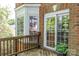Wooden deck features a brick exterior with large windows and sliding doors, offering seamless indoor-outdoor living at 19113 Southport Dr, Cornelius, NC 28031