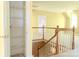 Second-floor hallway with hardwood railing, storage closet, and neutral paint at 19113 Southport Dr, Cornelius, NC 28031