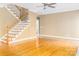 Bright living room featuring hardwood floors, a staircase, and a ceiling fan for added comfort at 19113 Southport Dr, Cornelius, NC 28031