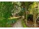 Lush backyard with a stone pathway, garden beds, and mature trees offers a serene outdoor retreat at 206 Coburn Ct, Fort Mill, SC 29715
