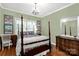 Inviting bedroom featuring a four-poster bed, chandelier, and natural light from large windows at 206 Coburn Ct, Fort Mill, SC 29715