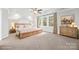 Spacious staged primary bedroom with tray ceilings, soft carpet, a window, and neutral decor at 206 Coburn Ct, Fort Mill, SC 29715