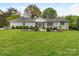 Expansive backyard featuring a lush lawn, a charming white house and dual patio seating areas at 2219 Richardson Dr, Charlotte, NC 28211
