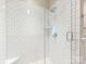 Close up of updated shower with white tile, glass surround, built-in niche and updated fixtures at 2219 Richardson Dr, Charlotte, NC 28211