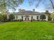 Charming white brick home with lush green lawn and manicured landscaping offers classic curb appeal at 2219 Richardson Dr, Charlotte, NC 28211