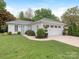 Charming exterior view of a white brick home with a manicured lawn and attached garage at 2219 Richardson Dr, Charlotte, NC 28211