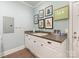 Functional laundry room with cabinets, sink, neutral walls and decor hanging on the walls at 2219 Richardson Dr, Charlotte, NC 28211