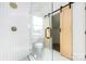 Modern shower featuring glass doors, white tile, and a convenient sliding barn door at 2230 W 6Th Ave, Gastonia, NC 28052