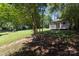 Secluded backyard with lush greenery, mature trees, and charming shed at 2404 Finchley Dr, Charlotte, NC 28215