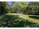 Expansive backyard with a charming shed and inviting fire pit area with Adirondack chairs at 2404 Finchley Dr, Charlotte, NC 28215