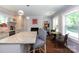 Open-concept kitchen featuring a large island with bar stools, seamlessly connected to a cozy dining area at 2404 Finchley Dr, Charlotte, NC 28215