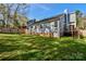 Spacious fenced backyard featuring a deck, lush green grass, and mature trees offering shade and privacy at 2731 Bishopton Pl, Charlotte, NC 28216
