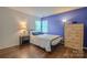 Cozy bedroom featuring hardwood floors, natural light, and contrasting gray and blue walls at 2731 Bishopton Pl, Charlotte, NC 28216