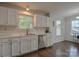Bright kitchen featuring white cabinets, stainless steel dishwasher, and hardwood floors at 2731 Bishopton Pl, Charlotte, NC 28216