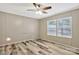 Bright bedroom featuring wood-look flooring, two windows, and a ceiling fan with lighting at 2749 Old Nation Rd, Fort Mill, SC 29715