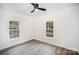 Bright bedroom features two windows, ceiling fan, and neutral paint to create a relaxing space at 308 Birch St, Lowell, NC 28098