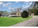 Charming home with a welcoming front porch, lush lawn, and gravel driveway at 308 Birch St, Lowell, NC 28098