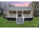 Charming home featuring a covered porch with decorative railings and inviting curb appeal at 308 Birch St, Lowell, NC 28098