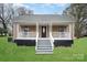 Charming home featuring a decorative front porch, and well-maintained lawn at 308 Birch St, Lowell, NC 28098