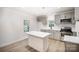 Bright modern kitchen with grey cabinets, quartz countertops, island, and stainless steel appliances at 308 Birch St, Lowell, NC 28098