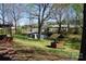 Large backyard with sheds, a brick well, steps to the house, and mature trees at 311 33Rd Street Se Dr, Hickory, NC 28602
