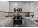 Kitchen with stainless steel stove and microwave, tiled backsplash and granite countertops at 315 Arlington Ave # 705, Charlotte, NC 28203