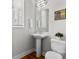 Bright bathroom featuring a pedestal sink, toilet, and neutral decor, with natural light from window at 324 Uptown West Dr, Charlotte, NC 28208