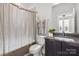 Well-lit bathroom featuring a shower with curtain, modern vanity, and neutral color scheme at 324 Uptown West Dr, Charlotte, NC 28208