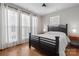 Bedroom features hardwood floors, a dark wood bed frame, and abundant natural light from large windows at 324 Uptown West Dr, Charlotte, NC 28208