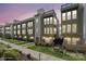Modern townhome showcasing multi-story facade, manicured lawn, and vibrant greenery, perfect for comfortable urban living at 324 Uptown West Dr, Charlotte, NC 28208