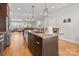 Modern kitchen with island seating, stainless appliances and an open floor plan flowing to the dining and living area at 324 Uptown West Dr, Charlotte, NC 28208