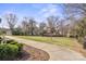 A well-maintained sidewalk leads through a grassy neighborhood common area with mature trees and inviting surroundings at 324 Uptown West Dr, Charlotte, NC 28208