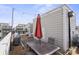 This rooftop deck features neutral siding, brown pavers, a patio table, and a red umbrella at 324 Uptown West Dr, Charlotte, NC 28208