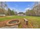 Large backyard with fire pit, lush green lawn, and white house in the background at 3565 Laboratory Rd, Lincolnton, NC 28092