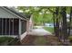 Long concrete driveway leading to a brick home with a screened-in porch and lush trees at 413 Parallel Dr, Harrisburg, NC 28075