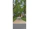 Long driveway leading to a brick home with a view of a storage shed in the backyard at 413 Parallel Dr, Harrisburg, NC 28075