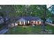 Beautifully landscaped front yard and classic brick facade of a single-story home, set back among mature trees at 413 Parallel Dr, Harrisburg, NC 28075