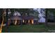 Charming single-story brick home with manicured lawn, flowerbeds, and welcoming front entrance enhanced by exterior lighting at 413 Parallel Dr, Harrisburg, NC 28075