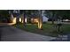 Lovely brick house with well-lit exterior, manicured lawn, landscaped yard and a driveway leading to an attached garage at 413 Parallel Dr, Harrisburg, NC 28075