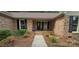 Inviting brick home entrance featuring well-kept landscaping and an oval-window front door at 413 Parallel Dr, Harrisburg, NC 28075