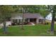 Charming brick home with blue shutters, mature landscaping, and a well-manicured lawn at 413 Parallel Dr, Harrisburg, NC 28075