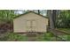 Exterior shot of backyard shed with double doors surrounded by lush greenery and split rail fence at 413 Parallel Dr, Harrisburg, NC 28075