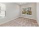 Sunlit bedroom with carpeted floors and a large window showcasing a picturesque outdoor view at 4141 Polluck Way, Charlotte, NC 28209