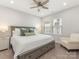 A bedroom with neutral tones, ceiling fan, plush carpet and a large window with wood blinds at 4141 Polluck Way, Charlotte, NC 28209