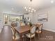 Elegant dining room features a wood table, chandelier, and seamless transition to the adjacent kitchen at 4141 Polluck Way, Charlotte, NC 28209